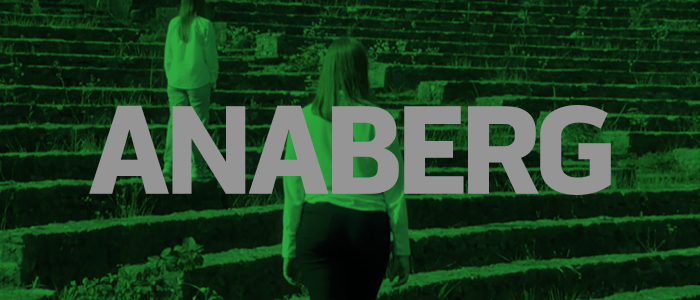 baner informacyjny zawierający napis "anaberg", zielone zdjęcie w tle przedstawia grupę kobiet stojących na widowni amfiteatru