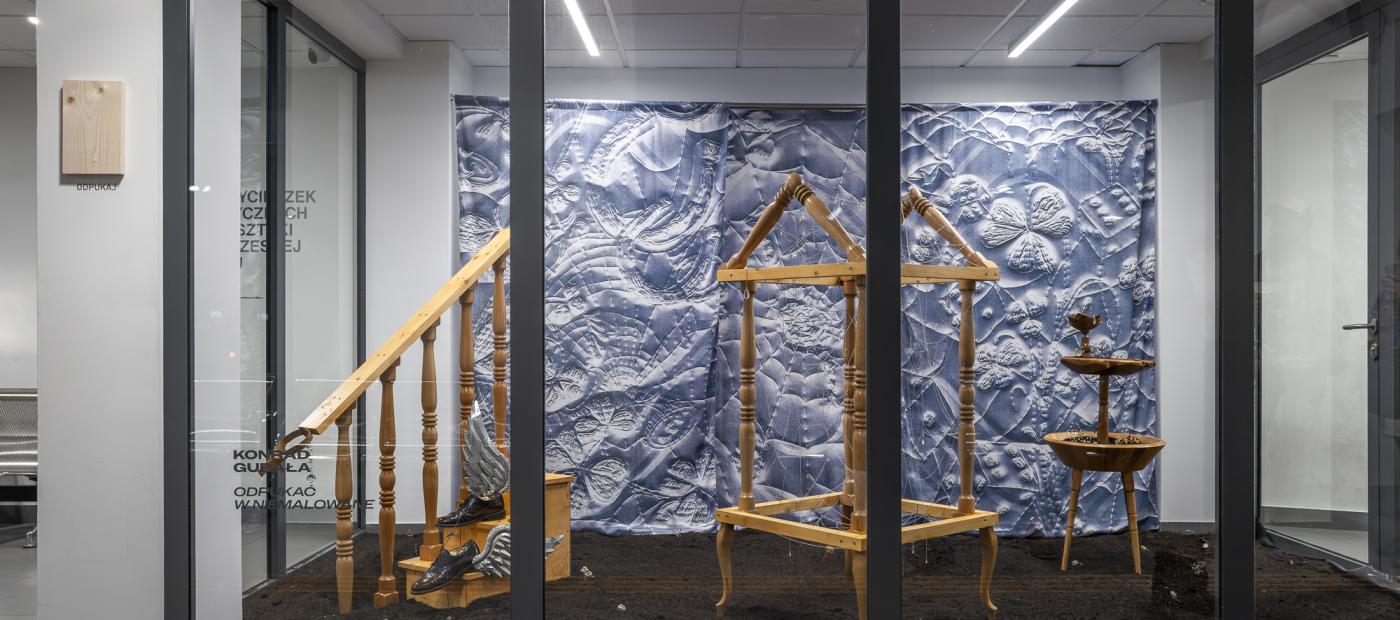 wystawa za szklaną ścianą, kilka obiektów sztuki ustawionych w przestrzeni