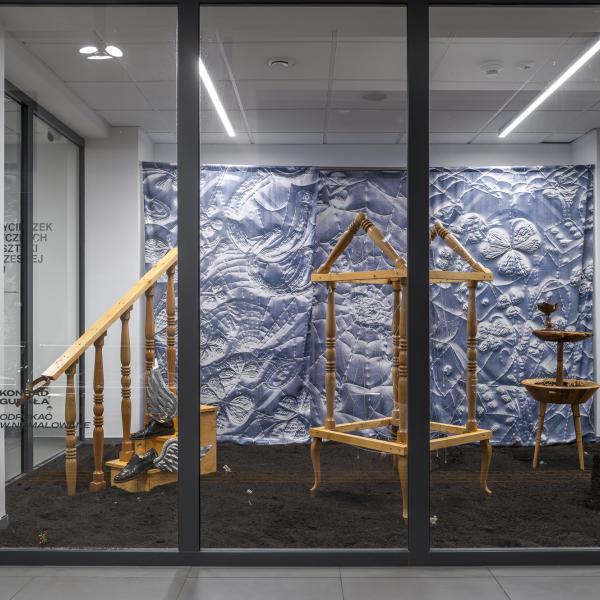 wystawa za szklaną ścianą, kilka obiektów sztuki ustawionych w przestrzeni