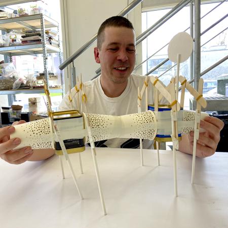 prowadzący warsztaty prezentuje obiekt artystyczny 