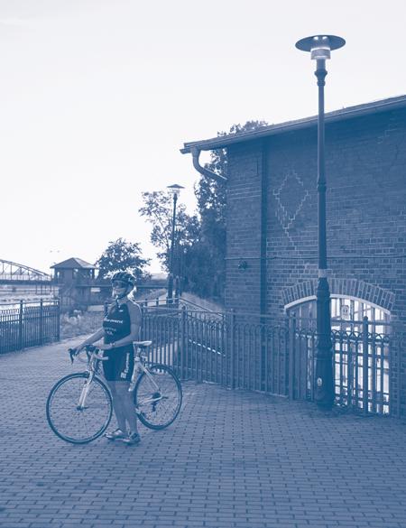 zdjęcie rowerzyski na tle odry i zabudować obok jazu w Opolu