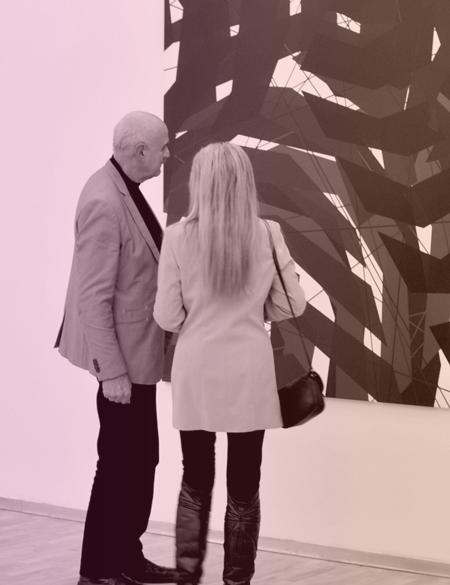 dwie osoby oglądają obraz w galerii