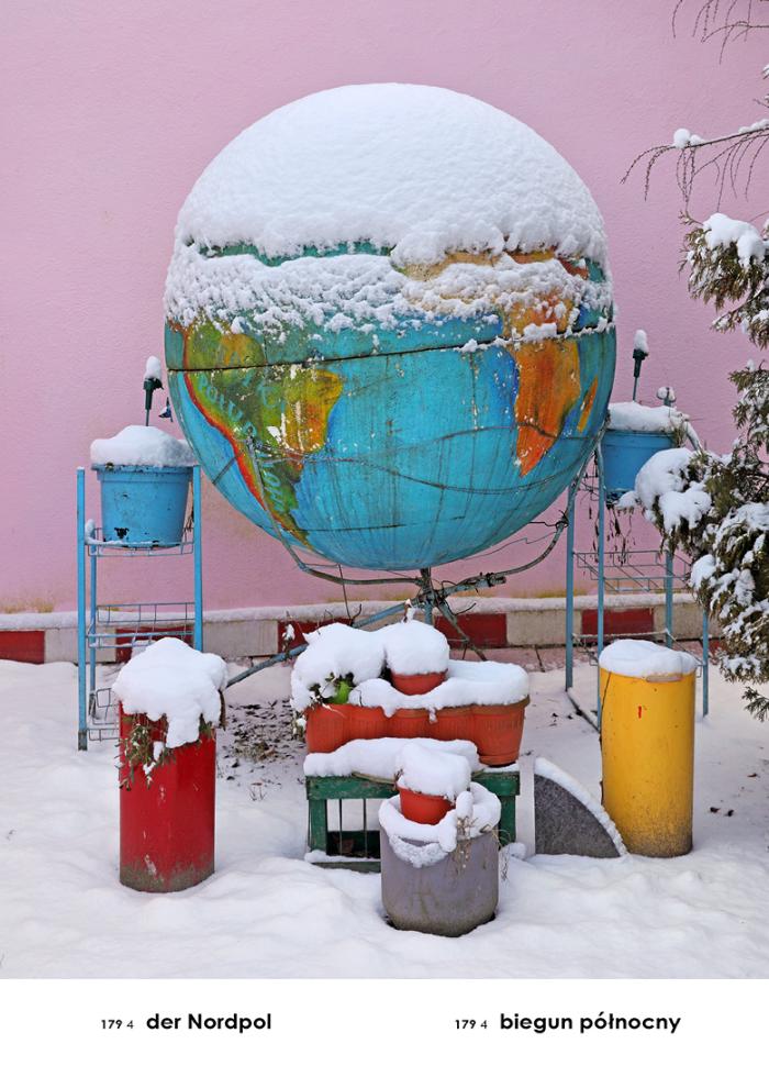 fotografia ukazująca globus ustawiony w mini ogródku, wokół chaotycznie rozstawione elementy  w różnych kolorach