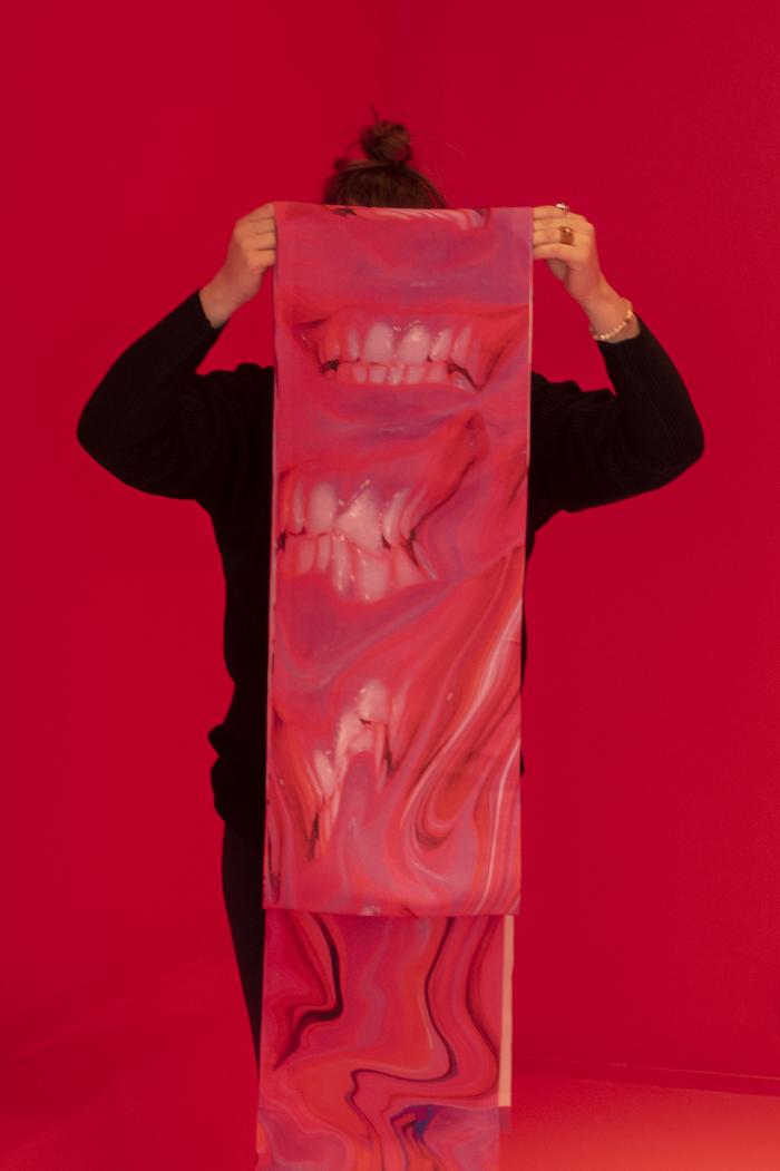 zdjęcie ukazujące kobietę zasłoniętą materiałem z nadrukowanymi motywami zębów