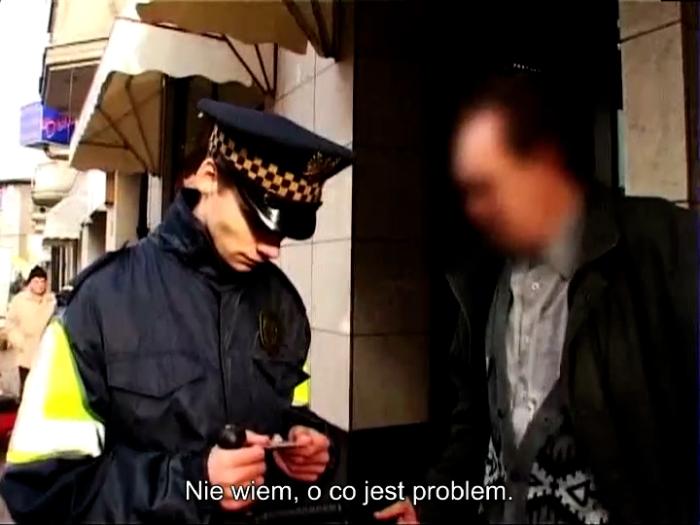 fotos z filmu, policjant i osoba zatrzymana, zamazana twarz. napis: ale o co chodzi